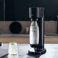 Máquina SodaStream Gaia preta com copo de água com gás
