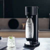 Máquina SodaStream Gaia preta com copo de água com gás
